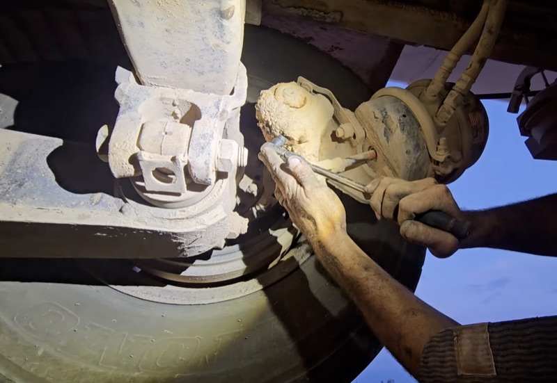 Hands-on brake slack adjuster repair on a semi truck axle assembly