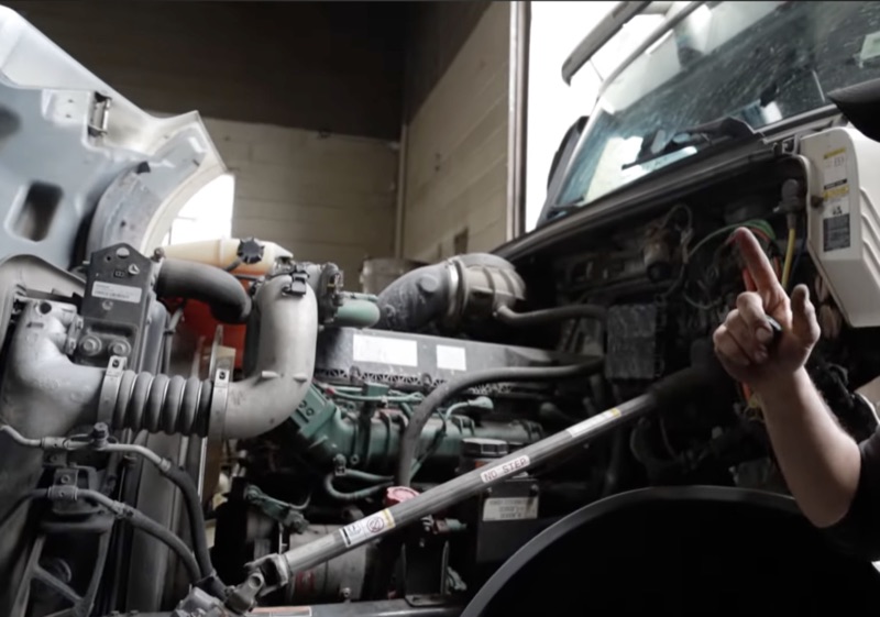 Semi truck with hood open exposing the full diesel engine for diagnostics